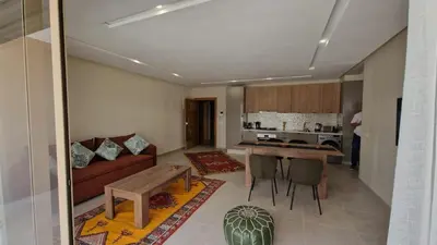 a living room with a couch and a table at New beachfront apartment in Oulad Akkou