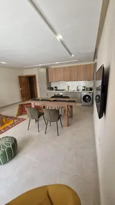 a kitchen with a table and chairs in a room at New beachfront apartment in Oulad Akkou