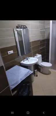 a bathroom with a sink and a toilet and a mirror at Bousstan 1er in Oulad Akkou