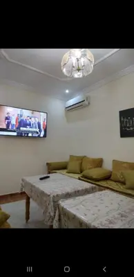 a living room with a table and a couch at Bousstan 1er in Oulad Akkou