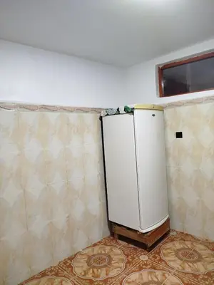 a small refrigerator in a room with a wall at Appartement REDA in Oulad Akkou
