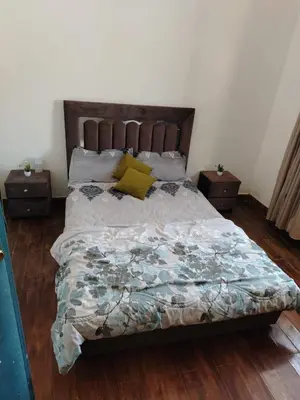 a bedroom with a large bed with two night stands at Ferme Maria in Tiflet