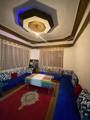 a living room with a blue couch and a ceiling at Ferme Maria in Tiflet