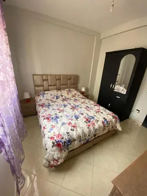 a bedroom with a bed with a floral comforter at Family apartment between Casa and Mohammedia in Oulad Akkou