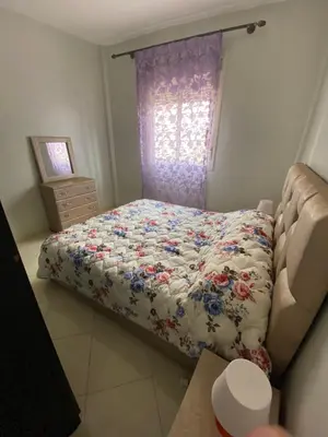 a small bedroom with a bed and a window at Family apartment between Casa and Mohammedia in Oulad Akkou