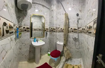 a bathroom with a sink and a toilet and a mirror at Family apartment between Casa and Mohammedia in Oulad Akkou