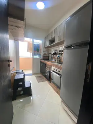 a kitchen with a stainless steel refrigerator and a table at Family apartment between Casa and Mohammedia in Oulad Akkou