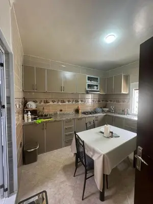 a kitchen with a table and a white table and chairs at Welcome to Tangier in Oulad Akkou