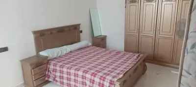 a small bedroom with a bed with a checkered blanket at Dar mustapha in Oulad Akkou
