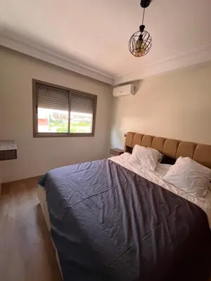 a bedroom with a large bed with a window at Appartement Moderne Hyper Centre in Oulad Akkou