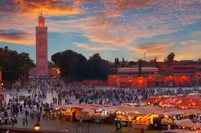 a crowd of people walking around a market with a clock tower at Appartement Moderne Hyper Centre in Oulad Akkou