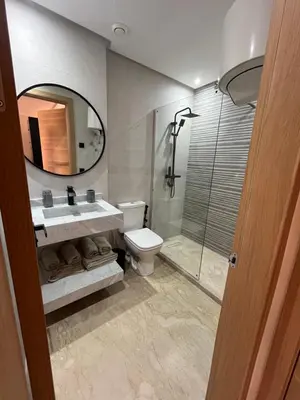 a bathroom with a toilet and a sink and a shower at Appartement Moderne Hyper Centre in Oulad Akkou