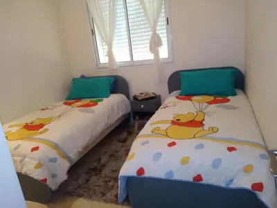 two beds in a small room with two bedsskirtsinylinylinylinyl at BOUZNIKA shems premium in Oulad Akkou