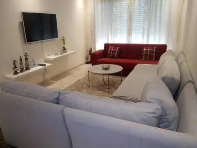 a living room with a couch and a tv at BOUZNIKA shems premium in Oulad Akkou