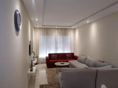 a living room with a couch and a red chair at BOUZNIKA shems premium in Oulad Akkou