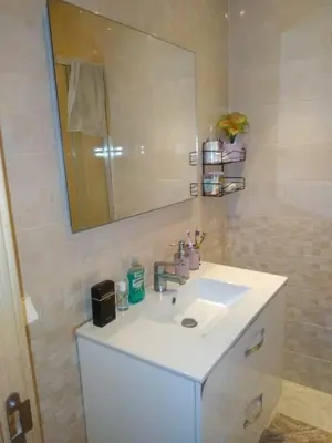a bathroom with a white sink and a mirror at BOUZNIKA shems premium in Oulad Akkou