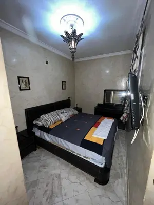 a bedroom with a bed and a television in it at Cozy apartment in center in Beni Mellal