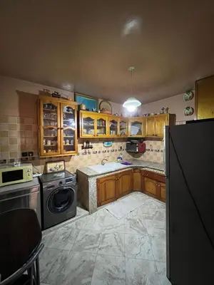 a kitchen with wooden cabinets and a dishwasher at Cozy apartment in center in Beni Mellal
