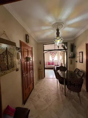 a dining room with a table and a chandelier at Cozy apartment in center in Beni Mellal