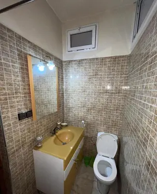 a bathroom with a toilet and a sink and a mirror at Cozy apartment in center in Beni Mellal