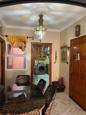 a dining room with a glass table and a chandelier at Cozy apartment in center in Beni Mellal