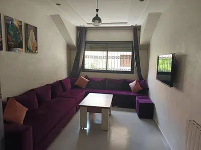 a living room with a purple couch and a table at Le Refuge de Vittel 5 in Ifrane