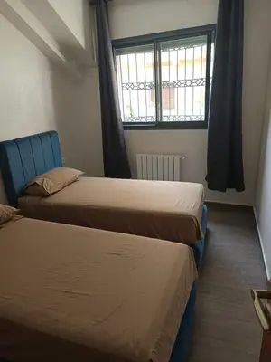two beds in a room with a window at Le Refuge de Vittel 5 in Ifrane