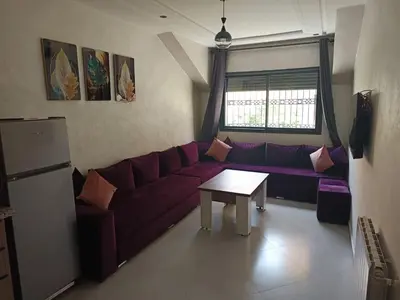 a living room with a purple couch and a table at Le Refuge de Vittel 5 in Ifrane
