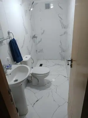 a white bathroom with a toilet and a sink at Le Refuge de Vittel 5 in Ifrane