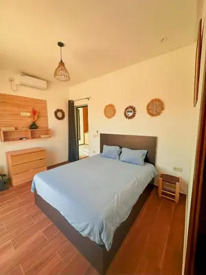 a bedroom with a large bed with blue pillows at Chic Duo Villas with Pool & Hammam in Ourika