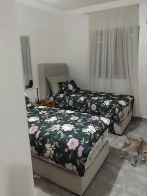 a bedroom with two beds and a window at Appartement moderne - Marrakech in Oulad Akkou