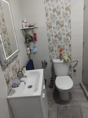 a bathroom with a white toilet and a sink at Appartement moderne - Marrakech in Oulad Akkou