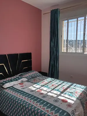 a bedroom with a bed with a quilt on it at caprice apparemment in Ifrane