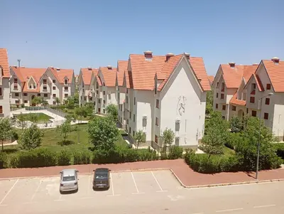 an apartment complex with cars parked in a parking lot at caprice apparemment in Ifrane