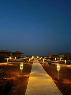 a walkway with lights in the desert at night at iMei Lux Camp \u7231\u6885\u91ce\u5962\u8425\u5730 in Lac Yasmins