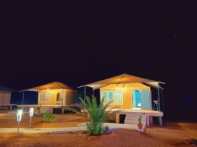 a row of houses with umbrellas in the desert at night at iMei Lux Camp \u7231\u6885\u91ce\u5962\u8425\u5730 in Lac Yasmins