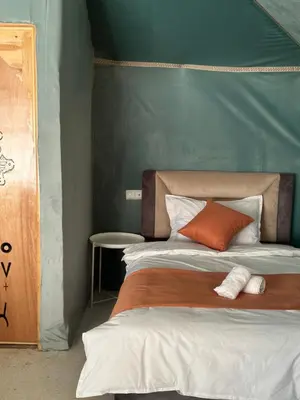 a bedroom with a bed with a green wall at iMei Lux Camp \u7231\u6885\u91ce\u5962\u8425\u5730 in Lac Yasmins