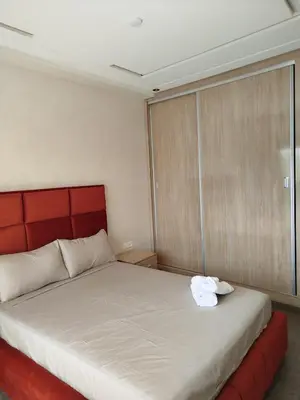 a bedroom with a large bed with a red headboard at Le Refuge de Vittel 2 in Ifrane