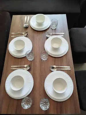 a wooden table topped with white plates and silverware at Le Refuge de Vittel 2 in Ifrane