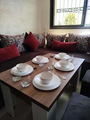 a wooden table with plates and wine glasses on it at Le Refuge de Vittel 2 in Ifrane