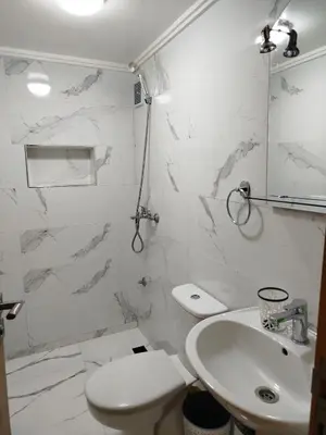 a white bathroom with a toilet and a sink at Le Refuge de Vittel 2 in Ifrane