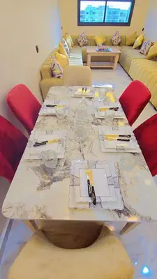 a large long table in a room with red chairs at Luxuriöse Wohnung in Fez in Fès