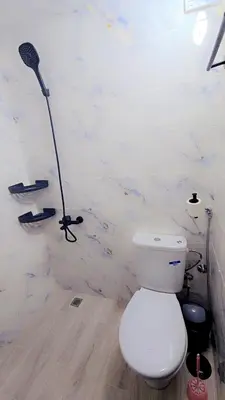 a white bathroom with a toilet and a shower at Luxuriöse Wohnung in Fez in Fès