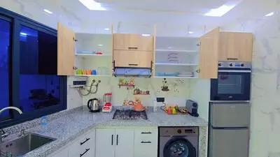 a kitchen with white cabinets and a washing machine at Luxuriöse Wohnung in Fez in Fès