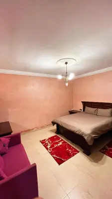a bedroom with a bed and a couch at Intimate villa Private pool et Atlas view in Sidi Bouzguia