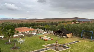 a garden with a tent and a fountain in the grass at Villa sans vis à vis Lina in Marrakech