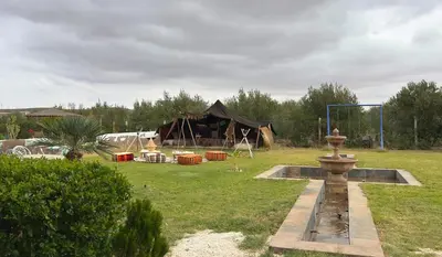 a tent in a field with a fountain in the grass at Villa sans vis à vis Lina in Marrakech