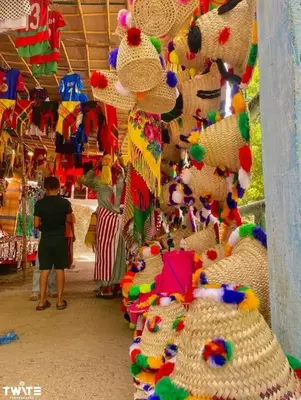 a person standing in a store with a pile of hats at دوار المروج بوعادل تاونات in Taounate