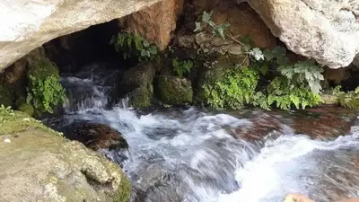 a stream of water flowing through a cave with rocks at دوار المروج بوعادل تاونات in Taounate