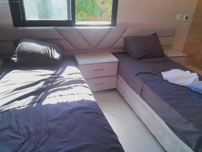 a bedroom with two beds and a dresser in it at Villa GHMAT in Aghmat